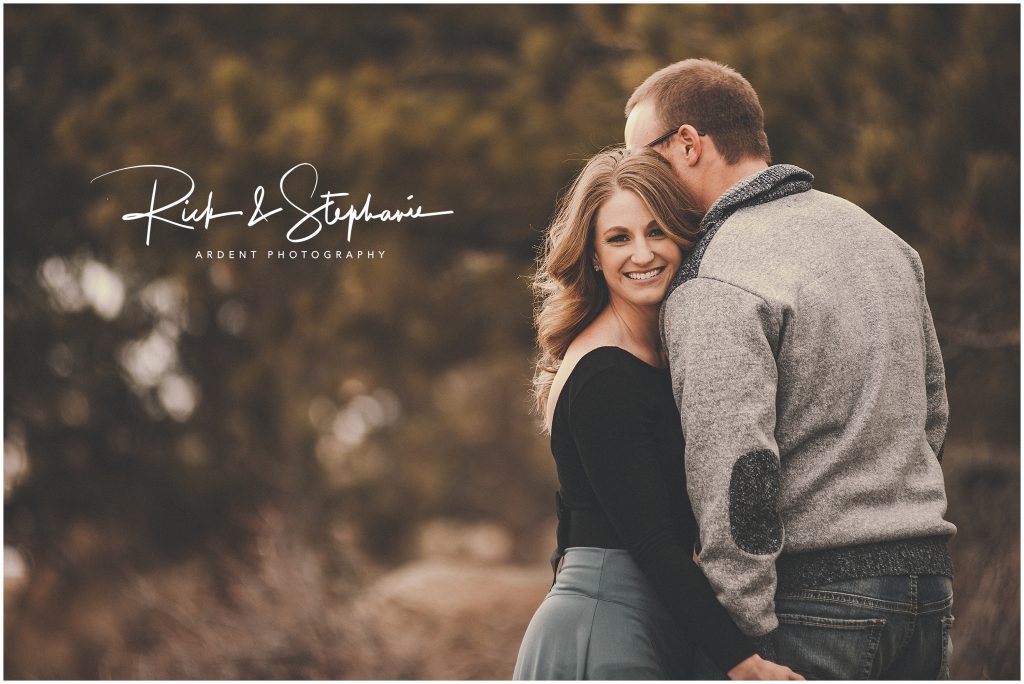 Close up photo of the bride looking at the camera and the groom snuggling in. Photographed during their Cheyenne WY engagement photo session.
