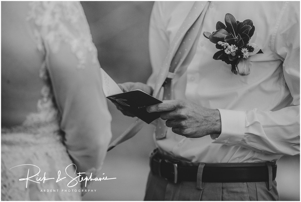 Groom holding how vow book open as he reads them aloud to the bride during this Cheyenne, WY wedding.