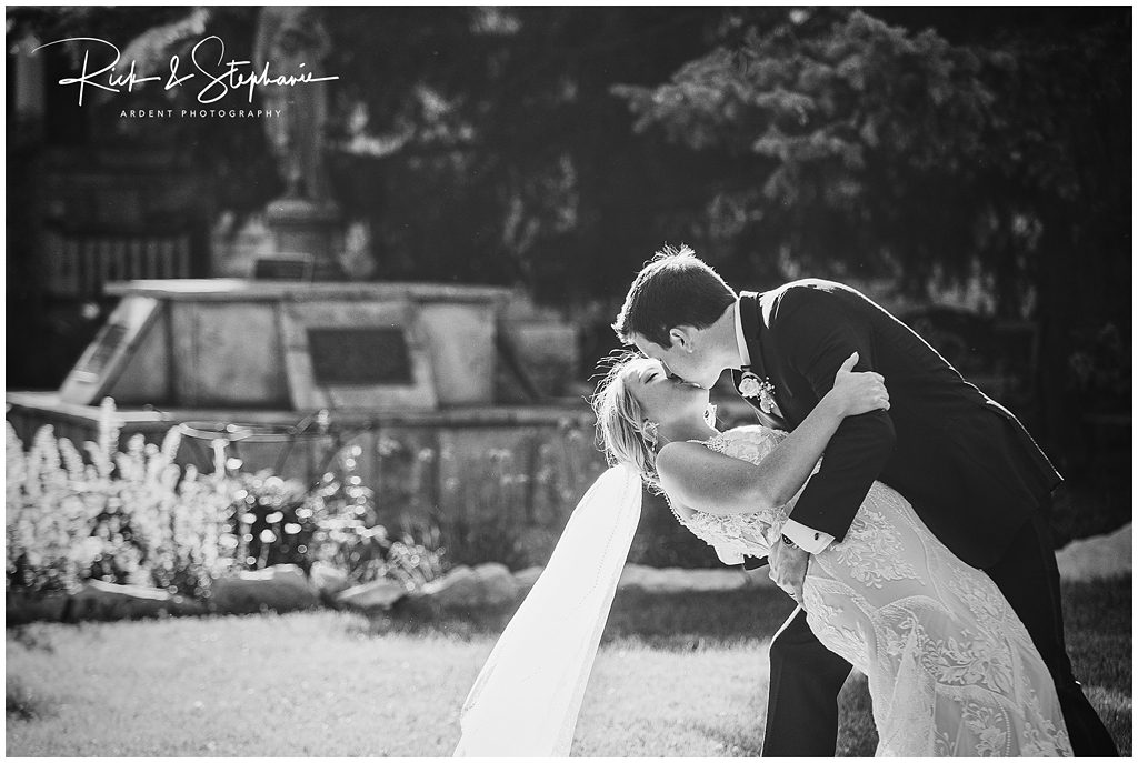 Black and white photo from an Ivinson Mansion wedding showing the groom kissing the bride.